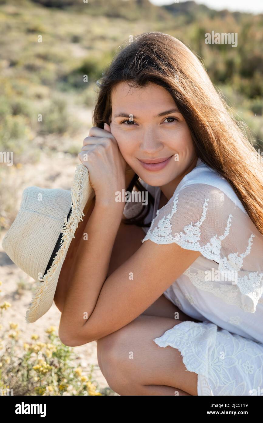 Portrait of woman in summer dress holding straw hat on beach Stock ...