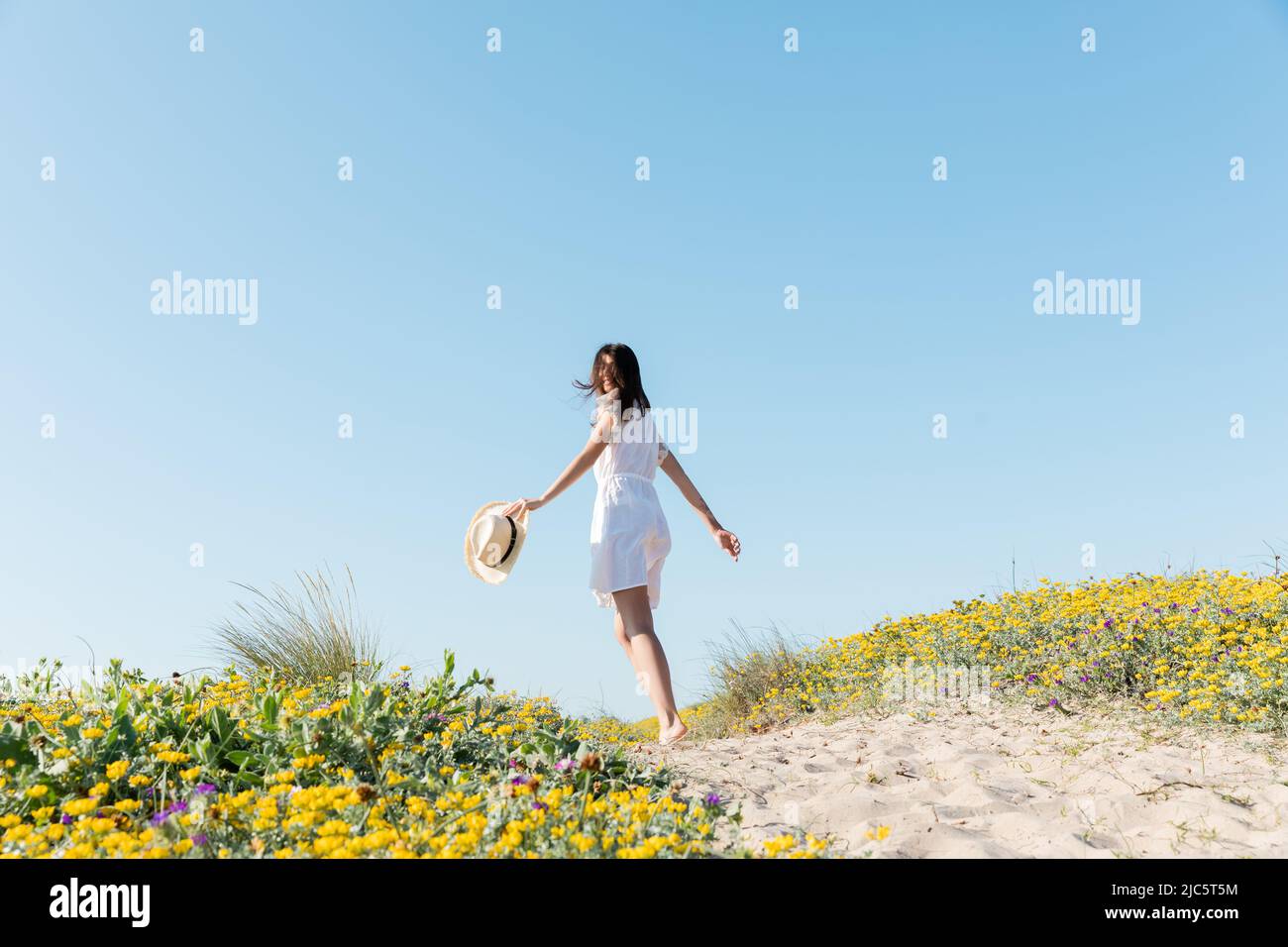 Woman holding sun hat hi-res stock photography and images - Alamy