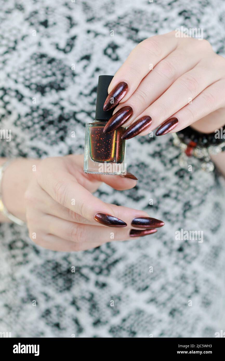 Female hands with long nails and black and red nail polish Stock Photo