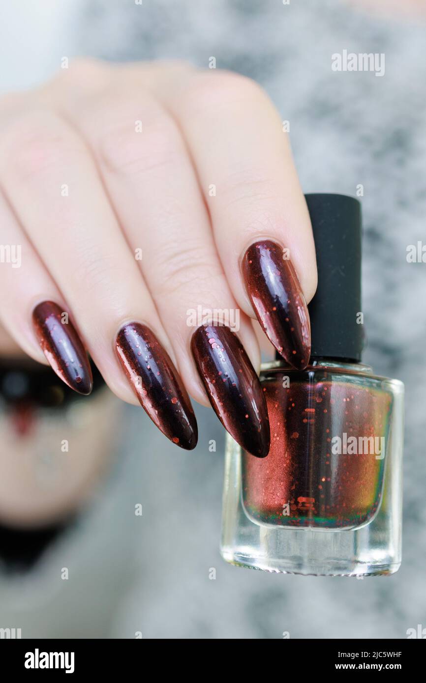 Female hands with long nails and black and red nail polish Stock Photo