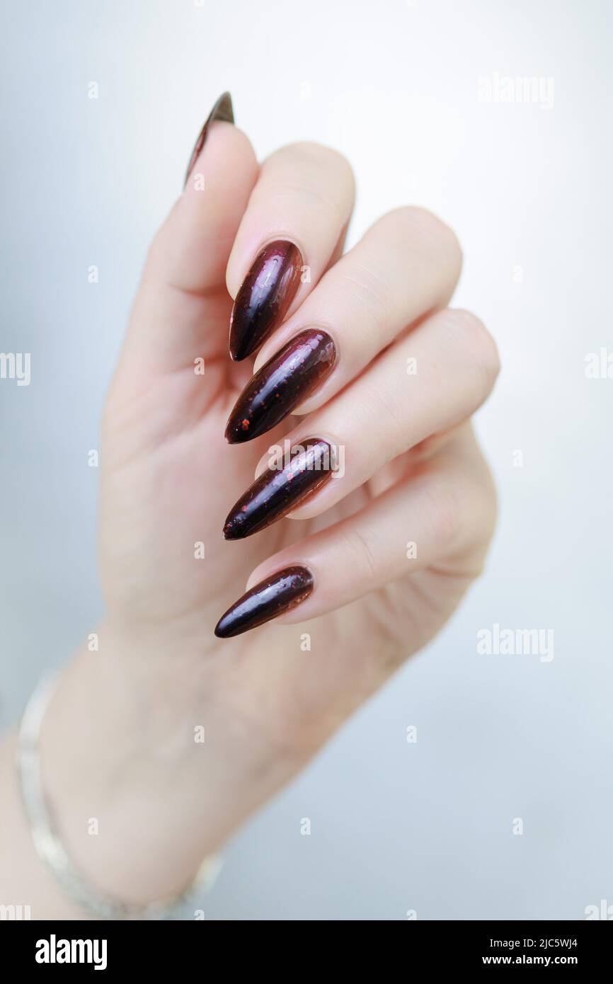 Female hands with long nails and black and red nail polish Stock Photo