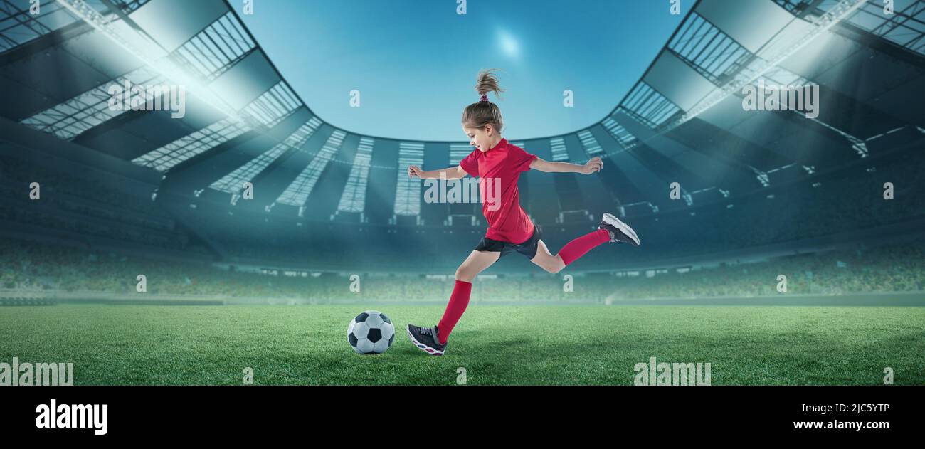 Portrait of little girl, football player in red uniform in motion