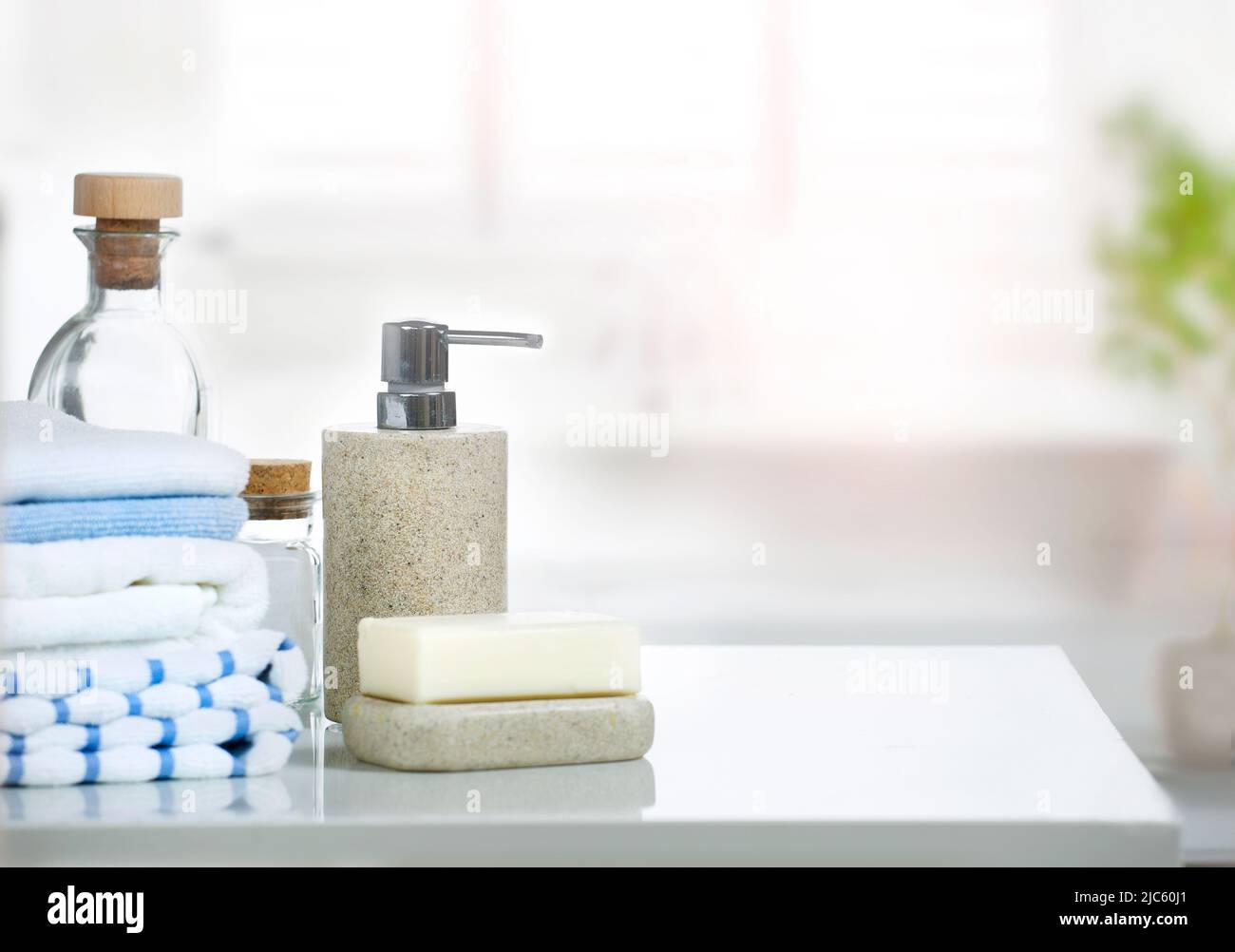 Soap,bathroom bottles set and stack of towels on white table indoor ...