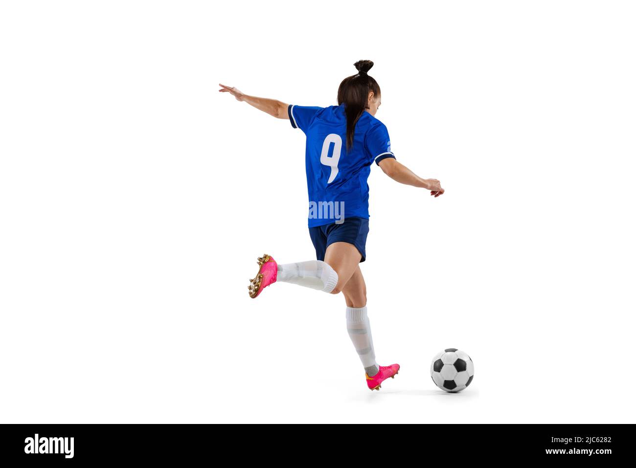 Dynamic portrait of female professional soccer, football player practicing isolated on white
