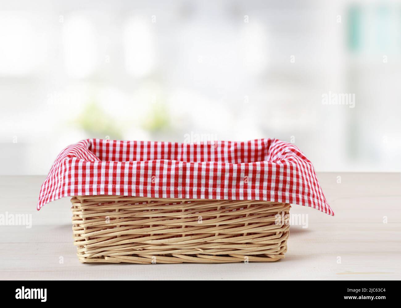Empty straw basket with red checkered picnic cloth empty space food