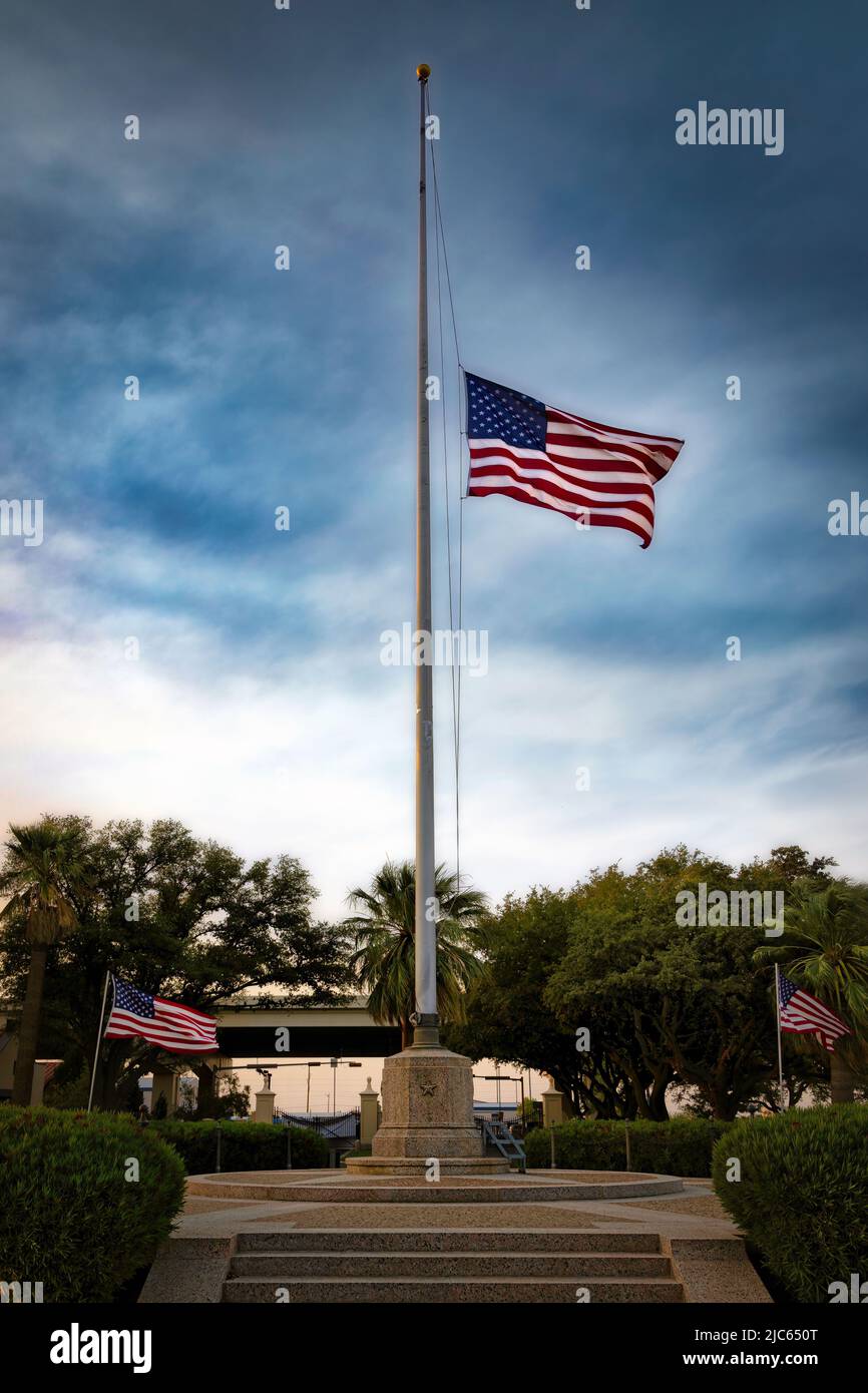 A flag raised to half mast, the night before Memorial Day, at a west