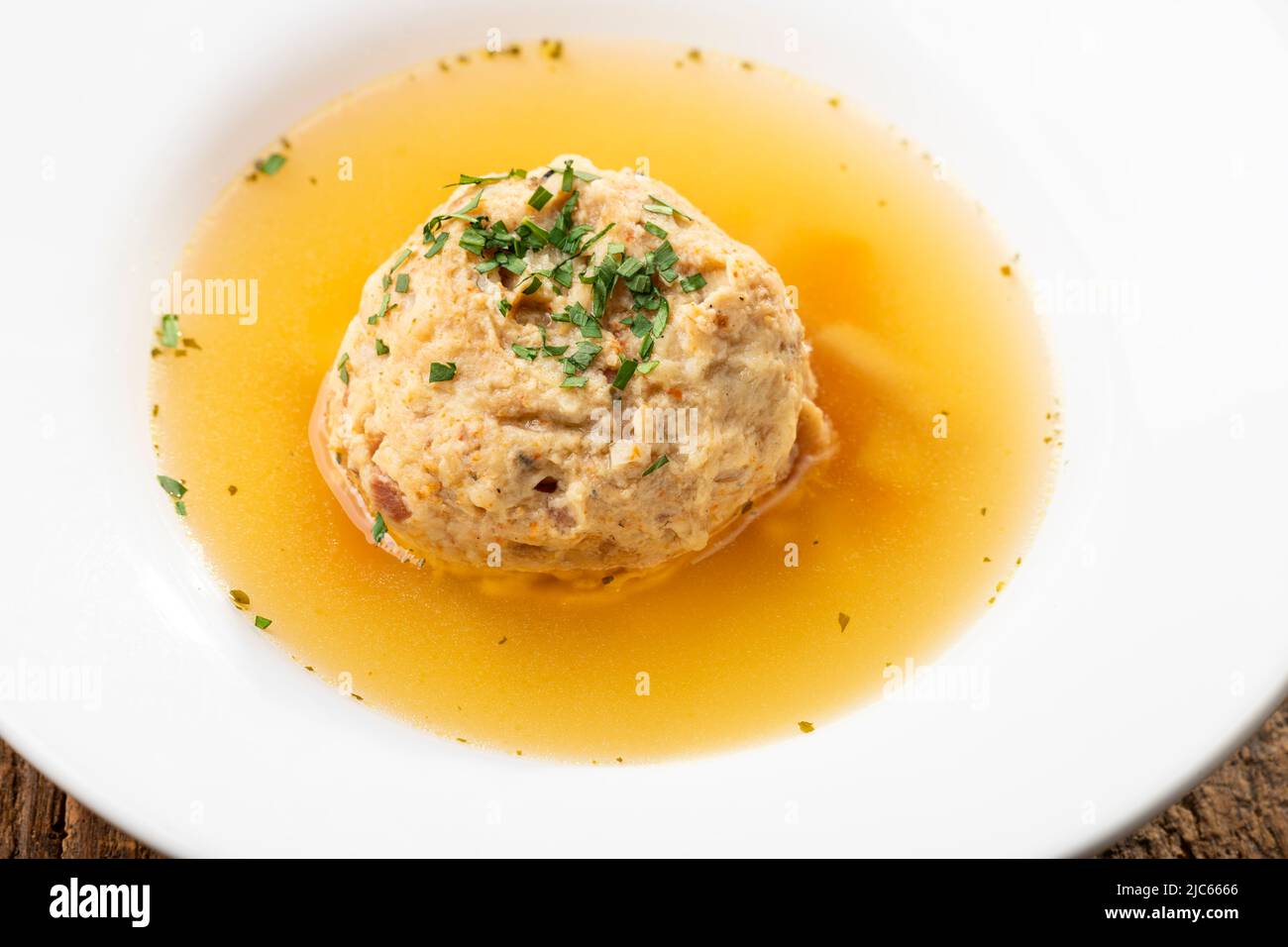 single speckknoedel in soup on wood Stock Photo