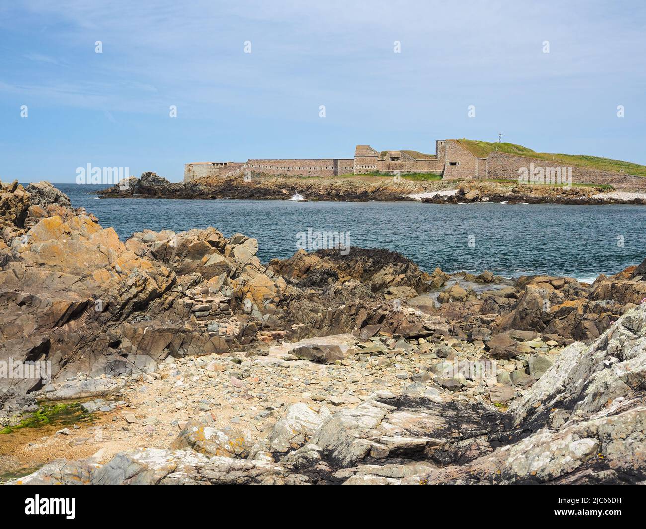 View across rocky bay to Fort Grosnez from Fort Doyle, Alderney, Channel Islands Stock Photo