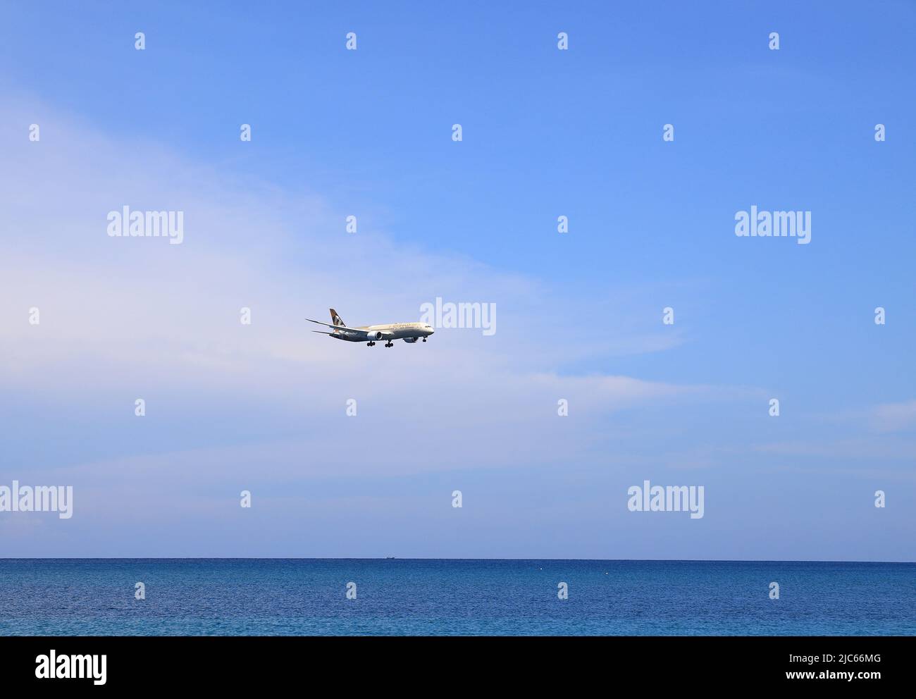 Airliner or Passenger plane Etihad Boeing 787-8 landing to airport next to the beach. airplane flies extremely low over the sea beach. Stock Photo