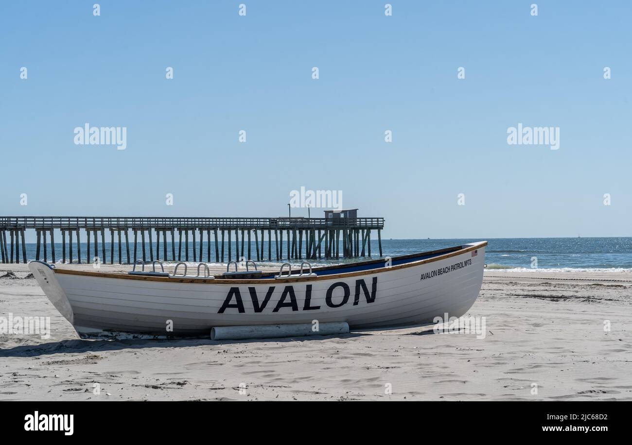 Summer days in Avalon, New Jersey. Avalon beach patrol boat on shore with fishing pier in the background. Stock Photo