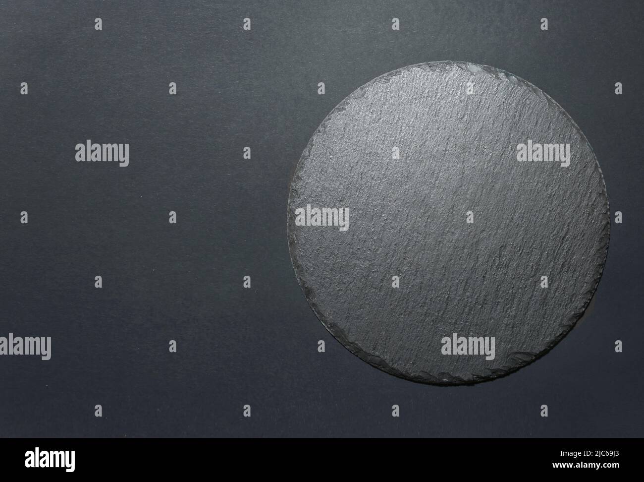 Round black slate dish plate top view empty copy space background. Stock Photo