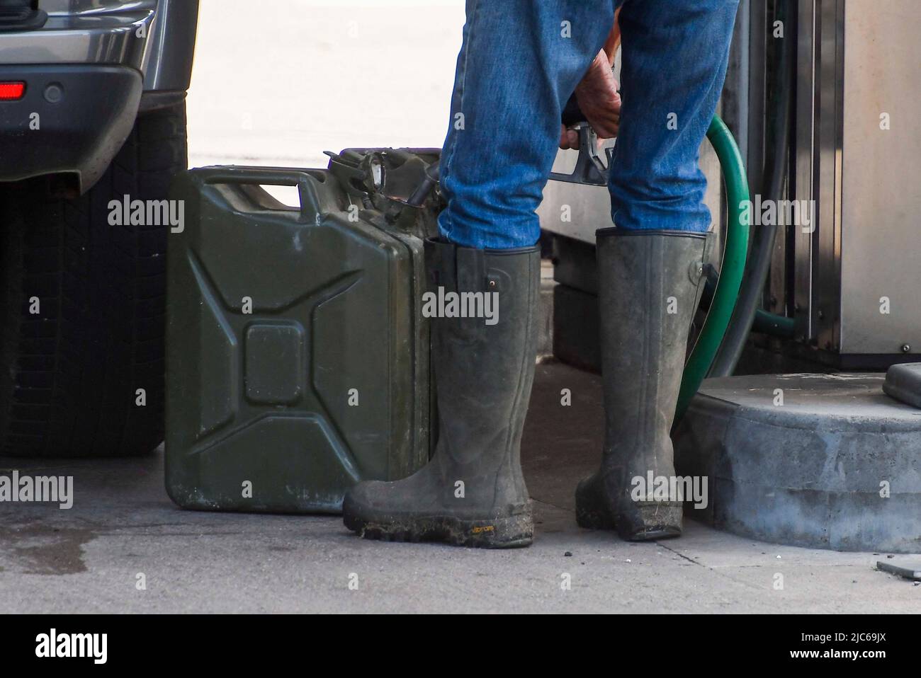 Axminster, Devon, UK. 10th June 2022. A motorist filling up two large