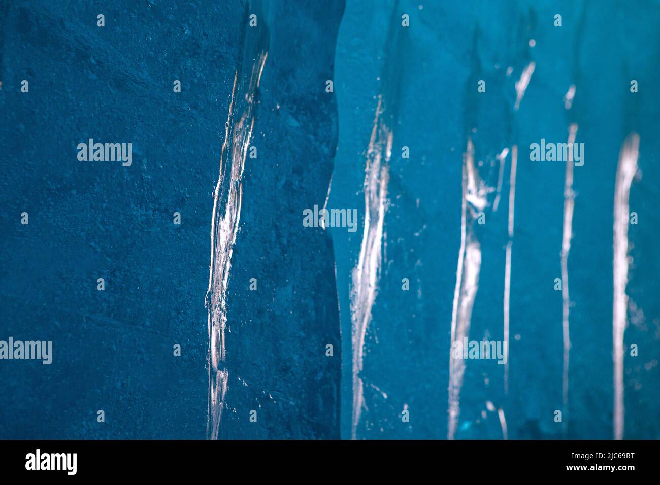 Blue ice texture background. Surface of ice block with light reflections. Stock Photo