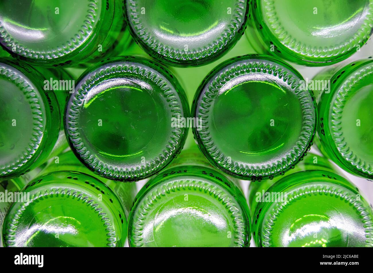 Bottoms of empty green glass bottles on white background, top view