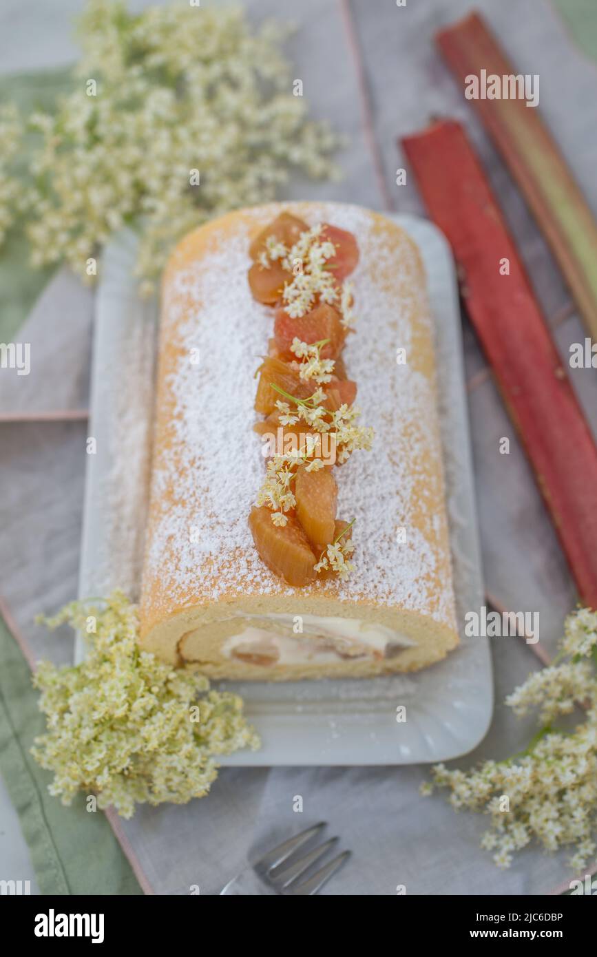Sweet home made bisuit roll with rhubarb and elderflower on a table Stock Photo