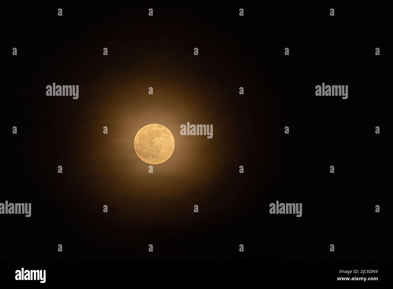 Full moon behind hazy clouds Stock Photo