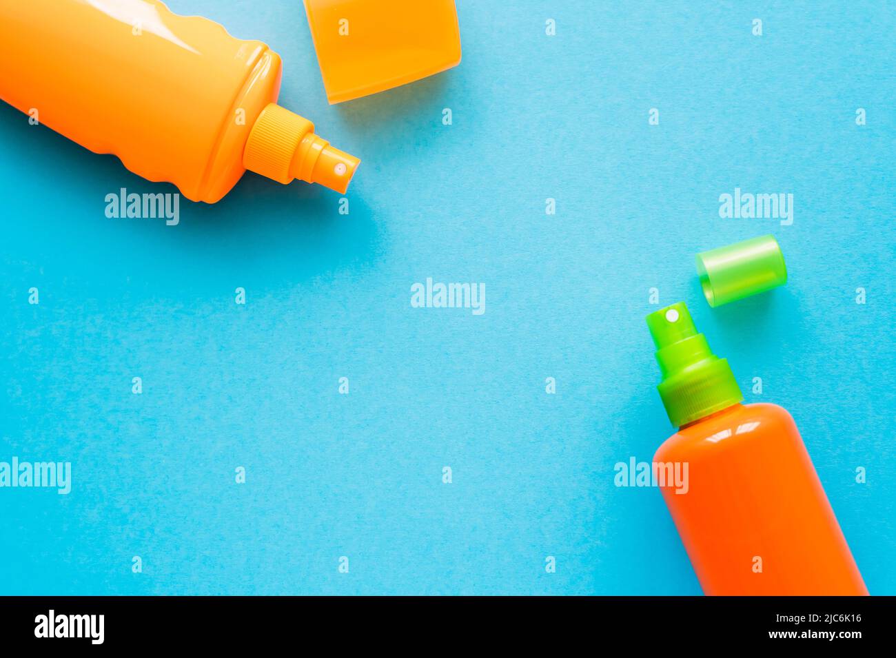 Top view of bottles of sunscreens with caps on blue background Stock Photo