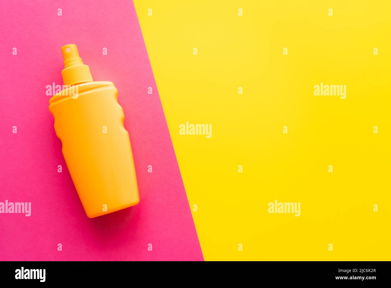 Top view of sunblock on pink and yellow background Stock Photo