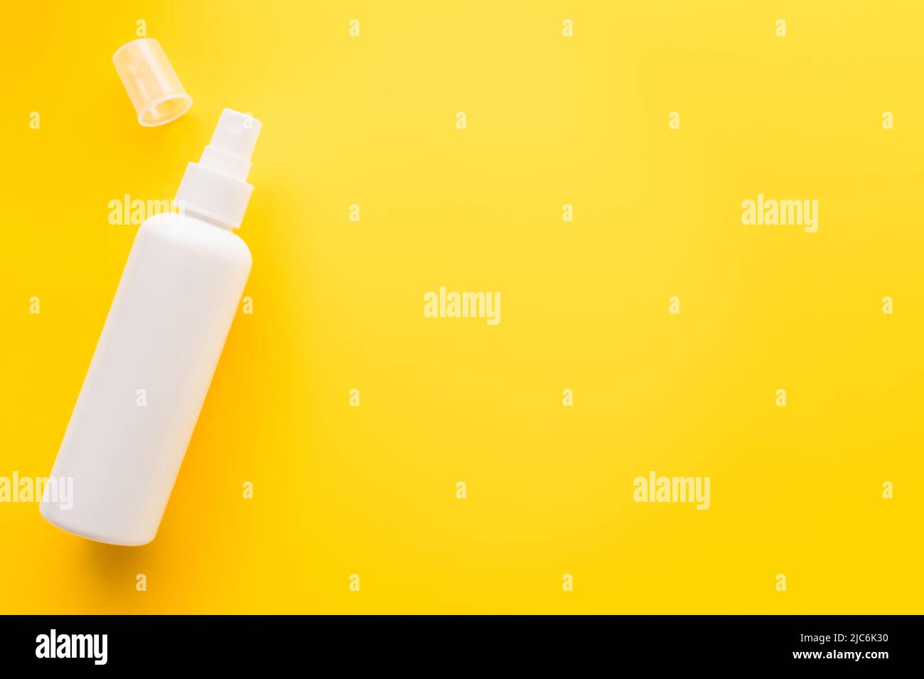 Top view of sunblock with cap on yellow surface Stock Photo