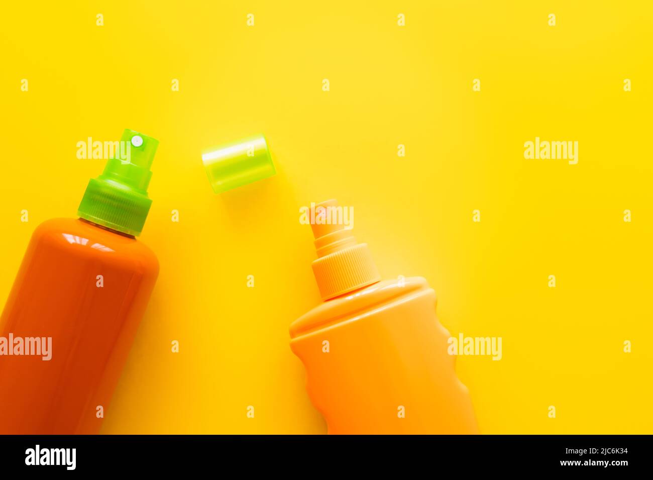 Top view of bottles of sunscreens on yellow surface Stock Photo
