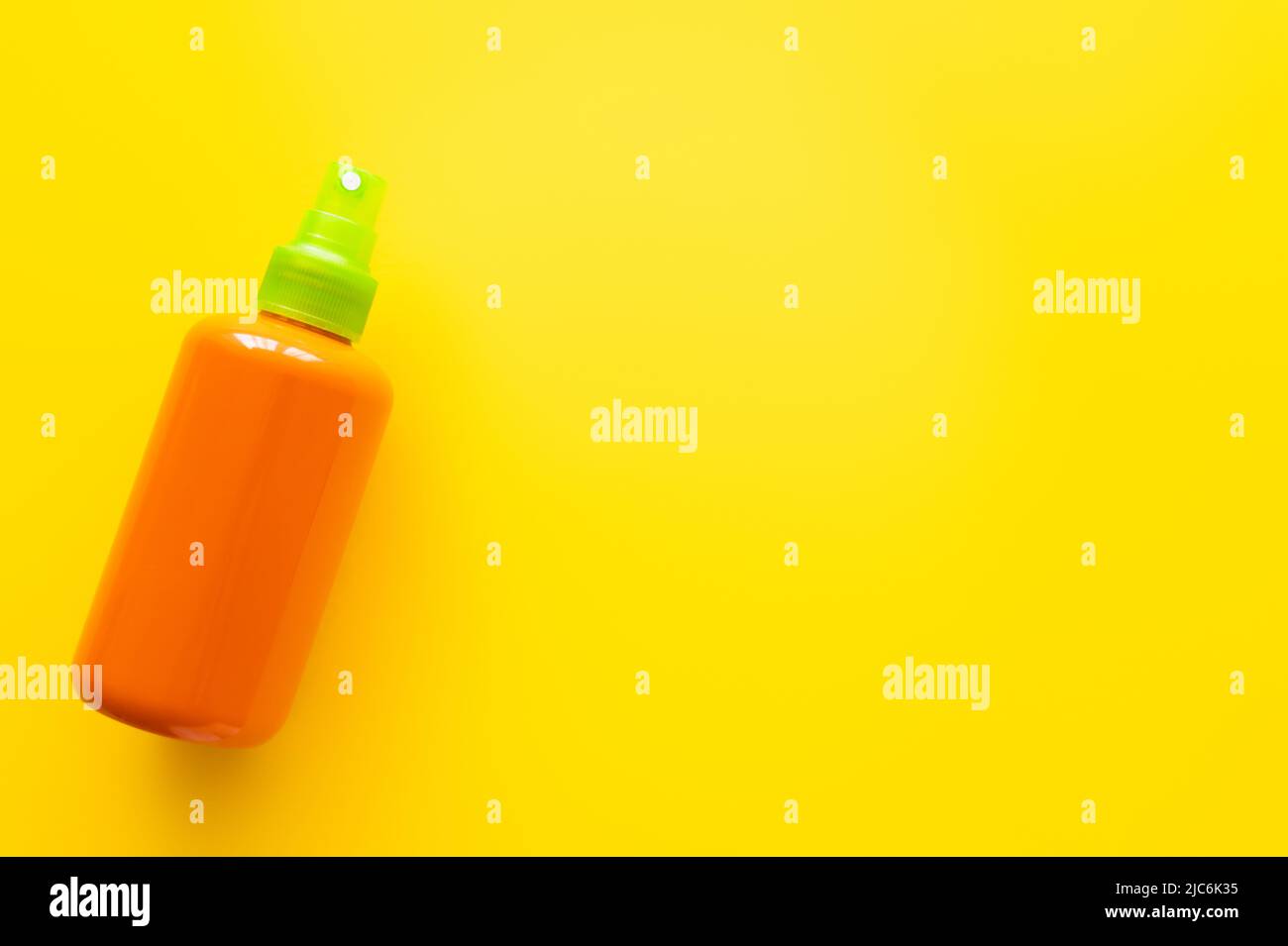 Top view of bottle of sunscreen on yellow surface Stock Photo