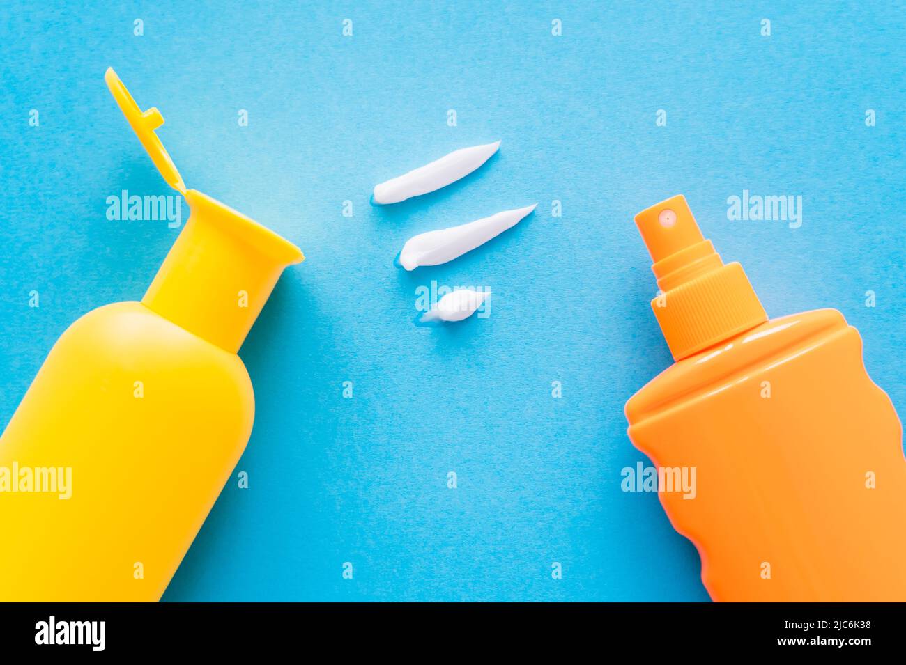 Top view of cream near sunscreens on blue background Stock Photo