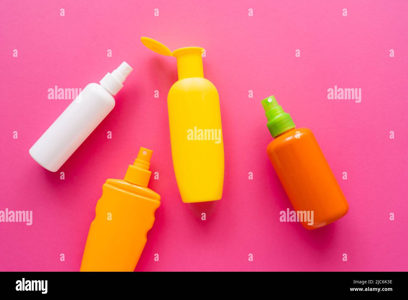 Top view of bottles of sunscreens on pink surface Stock Photo