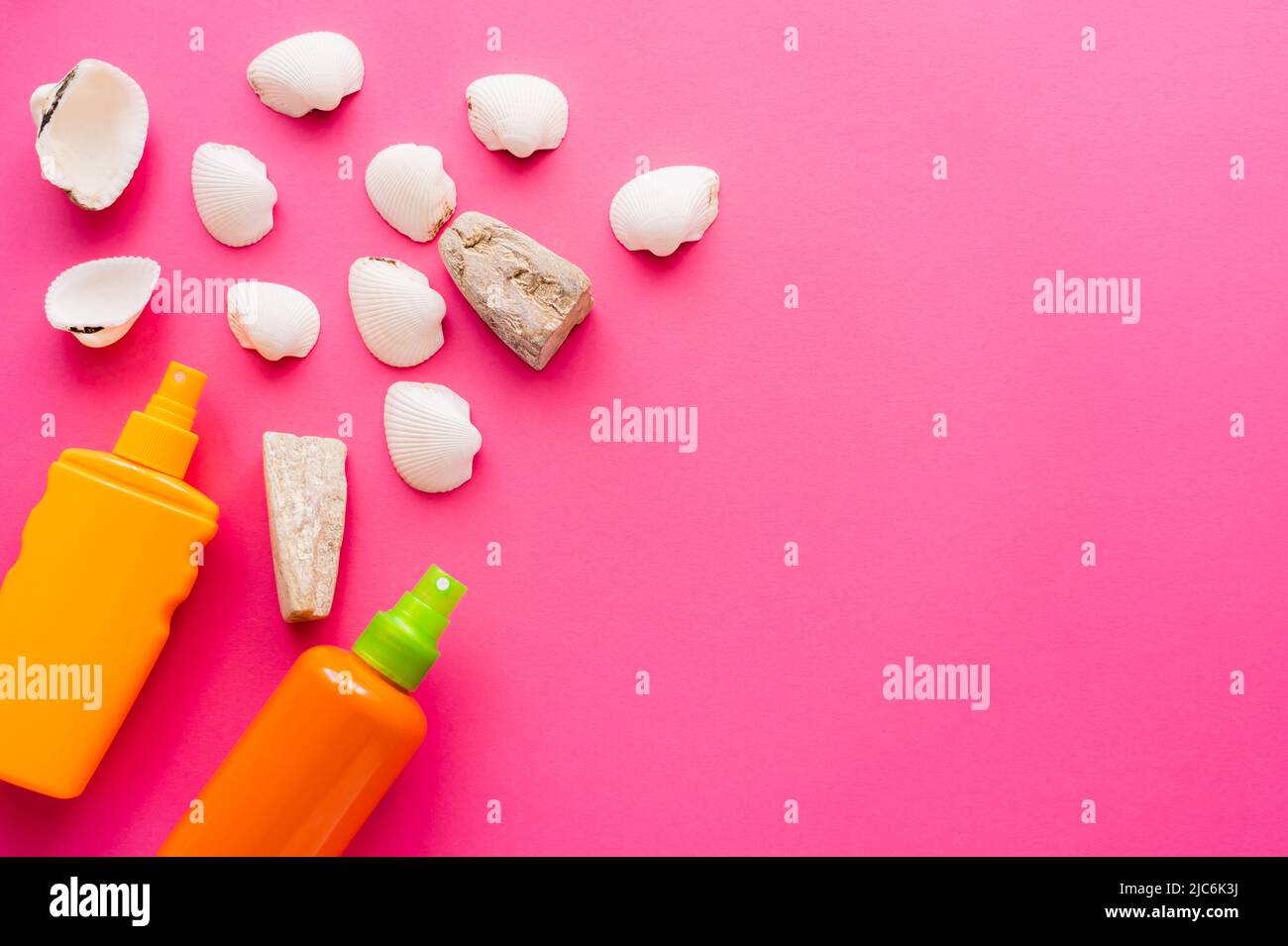 Top view of seashells and sunscreens on pink background Stock Photo