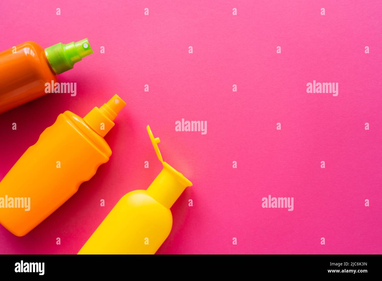Top view of sunscreens in bottles on pink surface with copy space Stock Photo