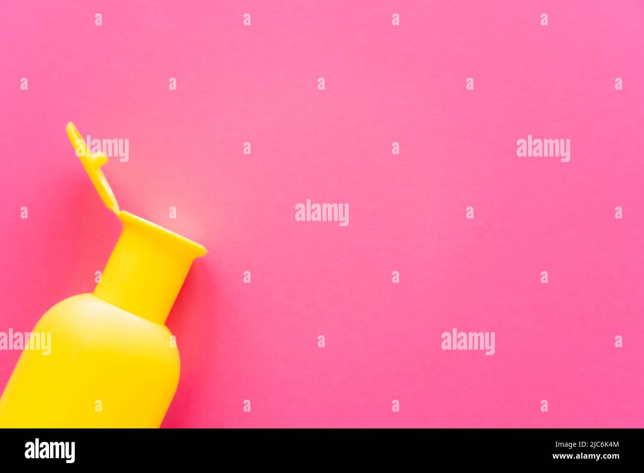 Top view of bottle of sunscreen on pink surface with copy space Stock Photo