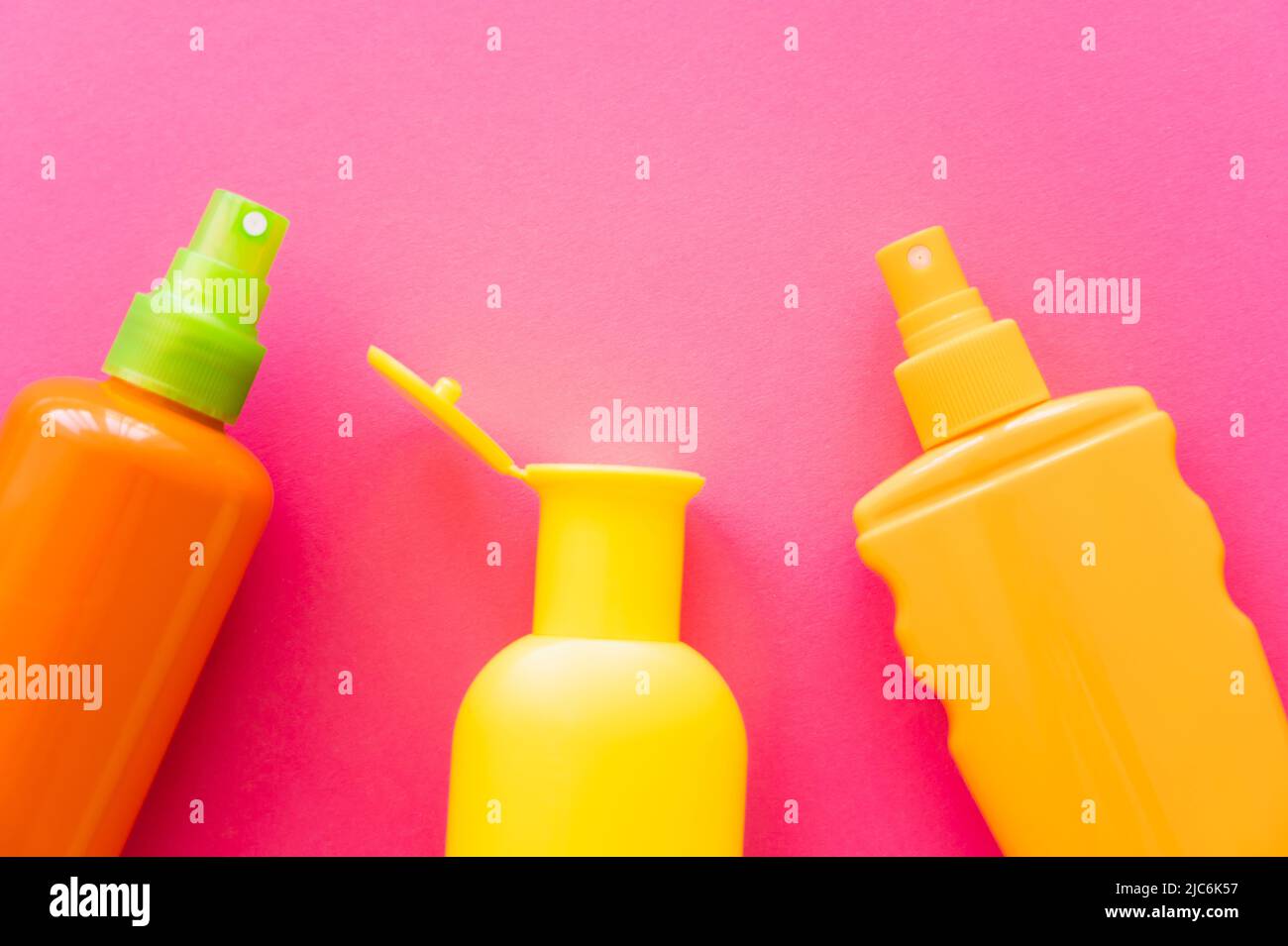 Top view of sunscreens on pink surface Stock Photo