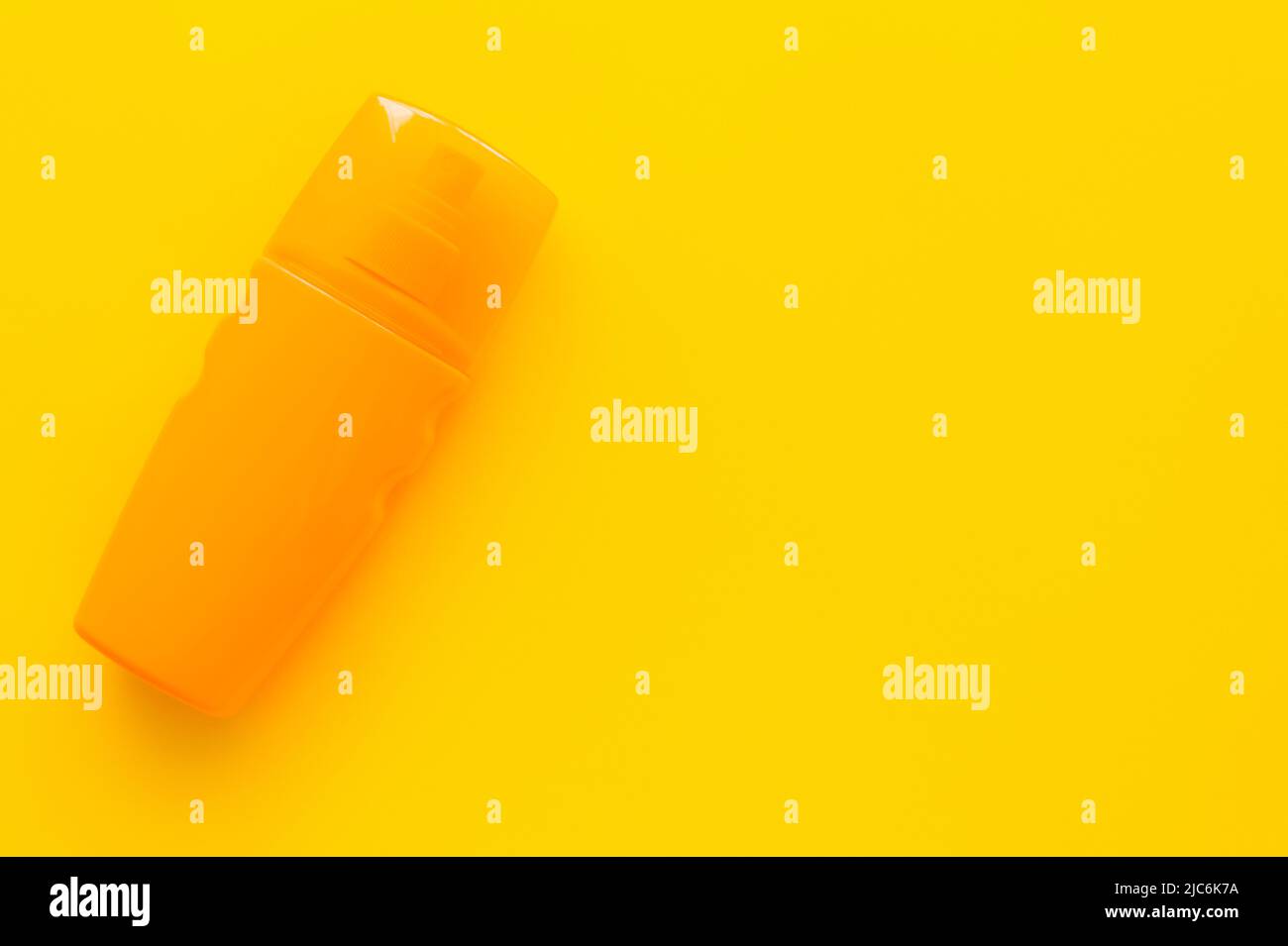 Top view of bottle of sunblock on yellow surface Stock Photo
