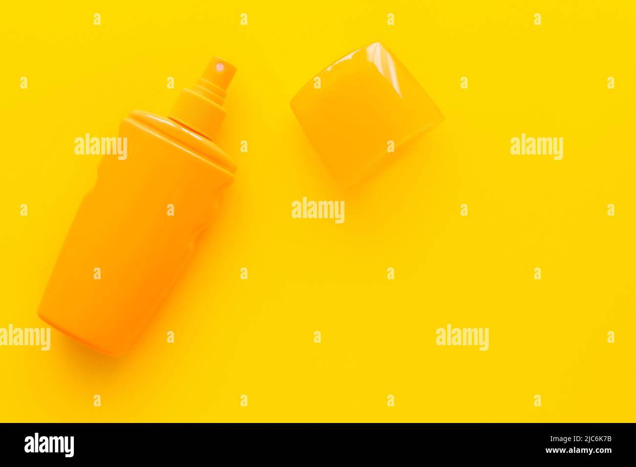 Top view of sunscreen with cup on yellow background Stock Photo