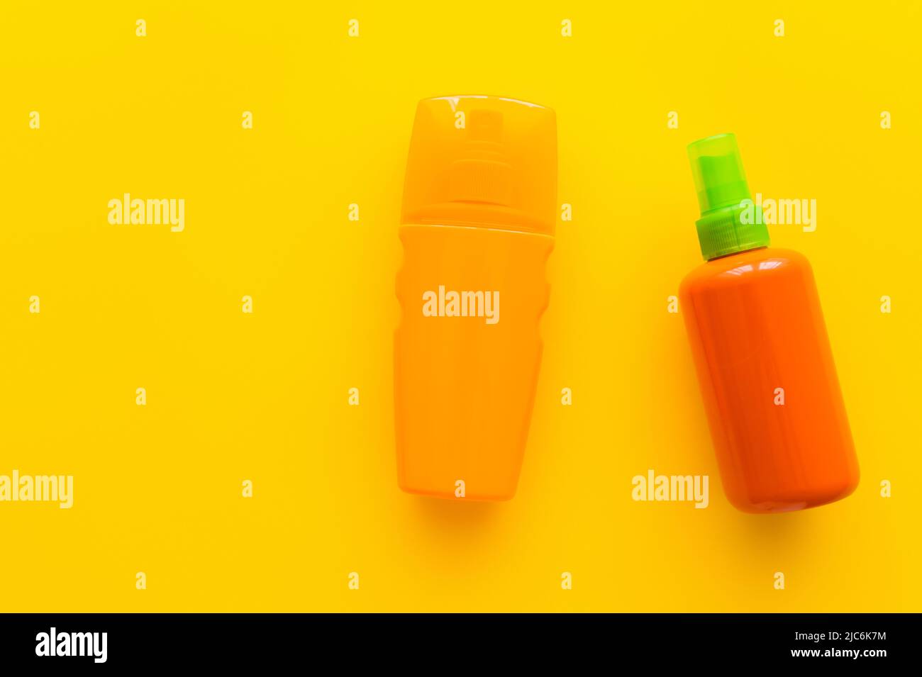 Top view of bottles of sunscreens on yellow background Stock Photo