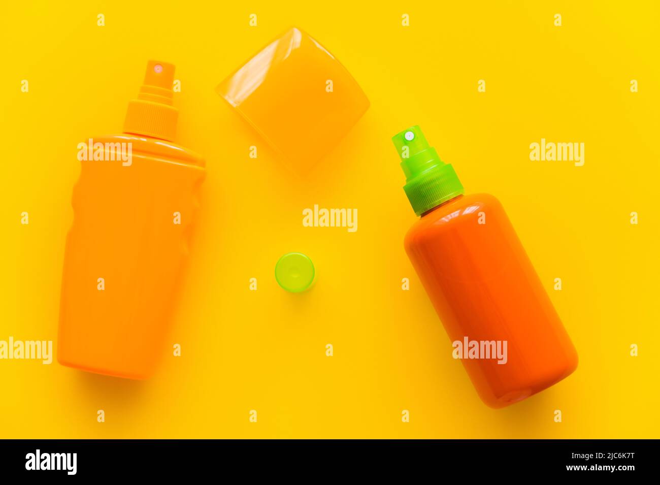 Top view of sunscreens bottles and caps on yellow background Stock Photo