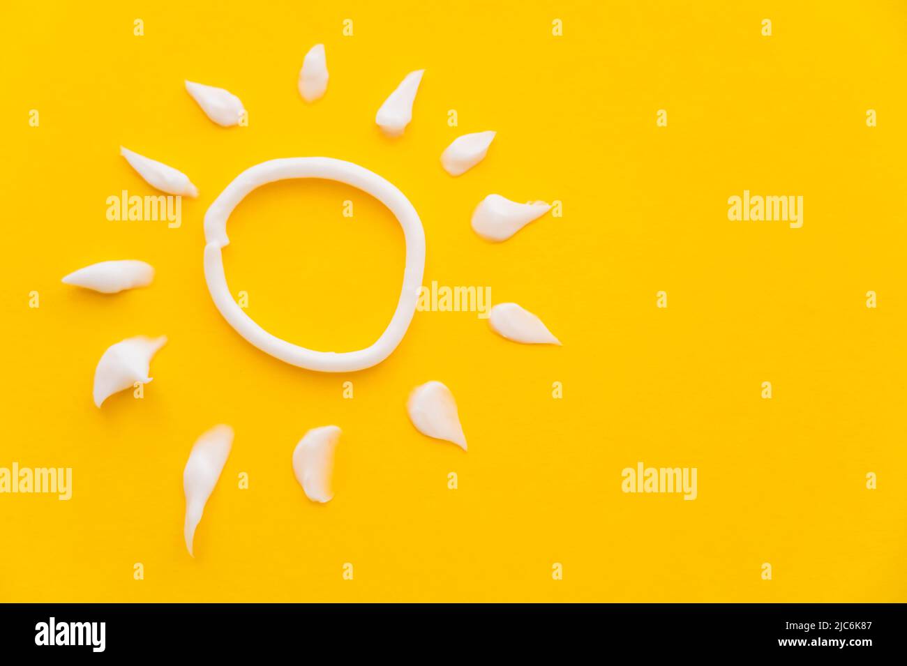 Top view of sun sign from sunscreen on yellow background Stock Photo