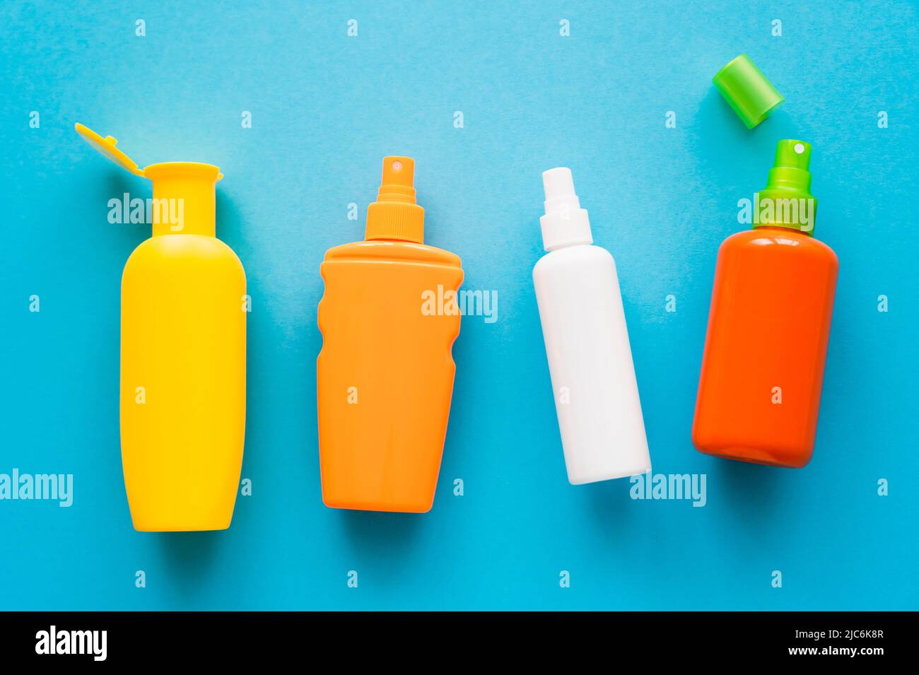 Top view of bottles of sunscreens on blue background Stock Photo