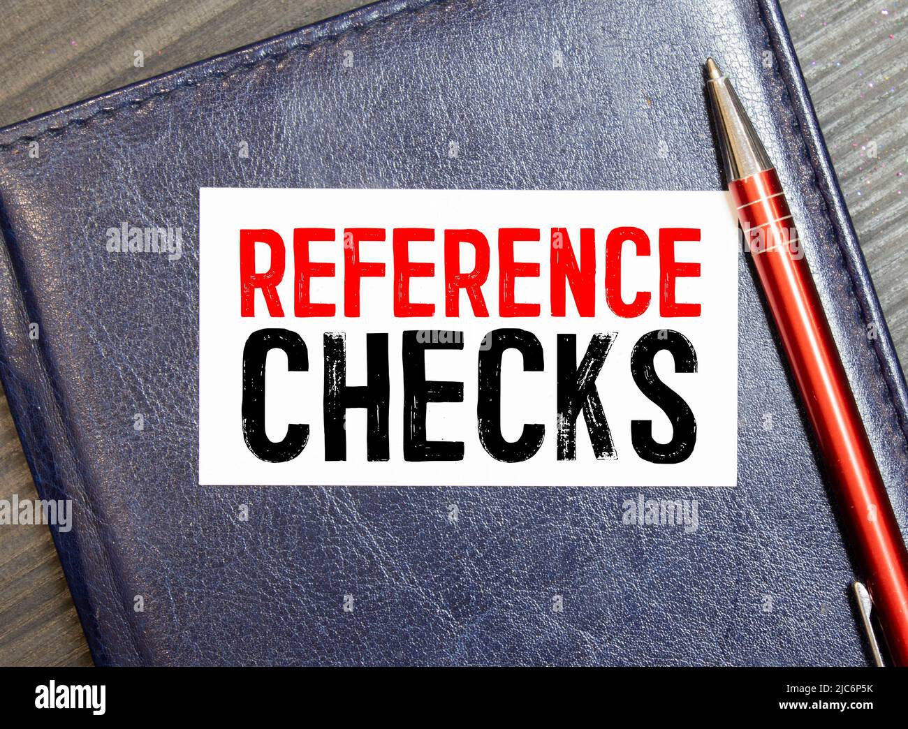 Closeup on businessman holding a card with REFERENCE CHECKS message ...