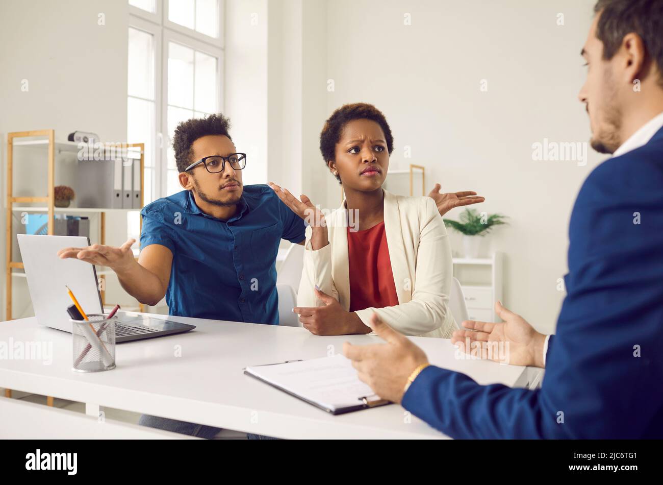Angry confused clients having misunderstanding with manager and demanding explanation Stock Photo