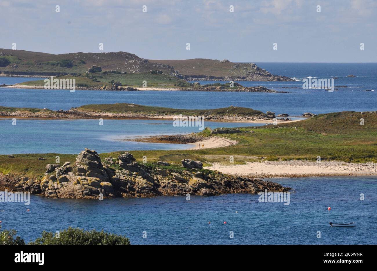 View from the western end of St Martin's island looking across the brilliant blue sea to the north end of Tresco. The sandy beaches on Tean and Forema Stock Photo