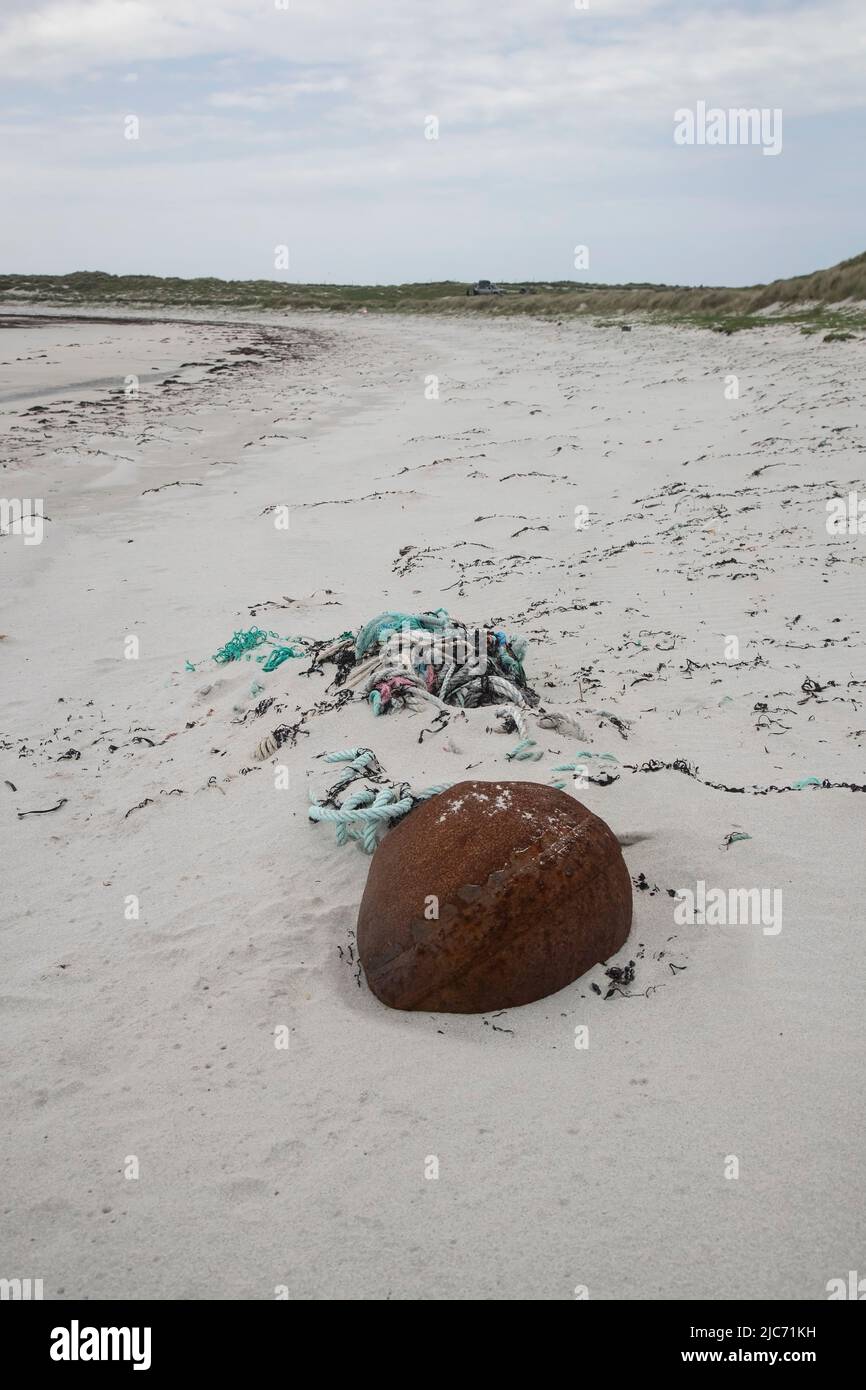 Flotsam and marine debris on the high strand line of a white sandy beach at North Uist, Outer Hebrides, comprising rope, netting and an iron weight Stock Photo