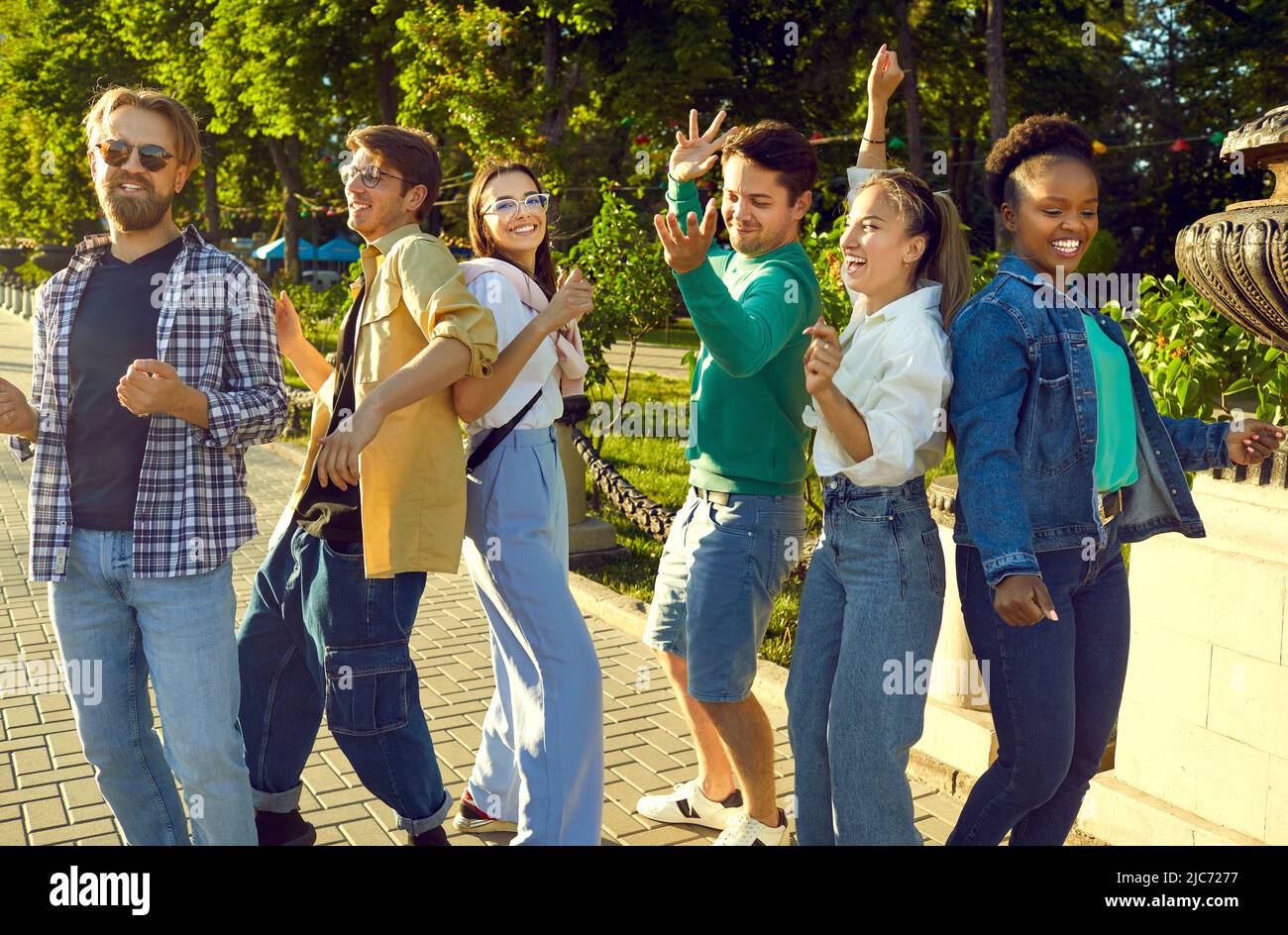 Happy young multiethnic friends meet up at the city park, dance, and have fun together Stock Photo