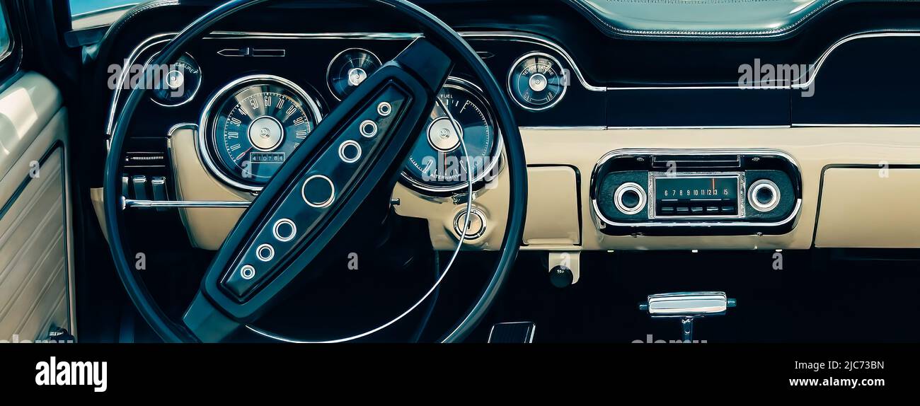 Retro styled image of an old classic sports car dashboard with black and white interiors. Stock Photo
