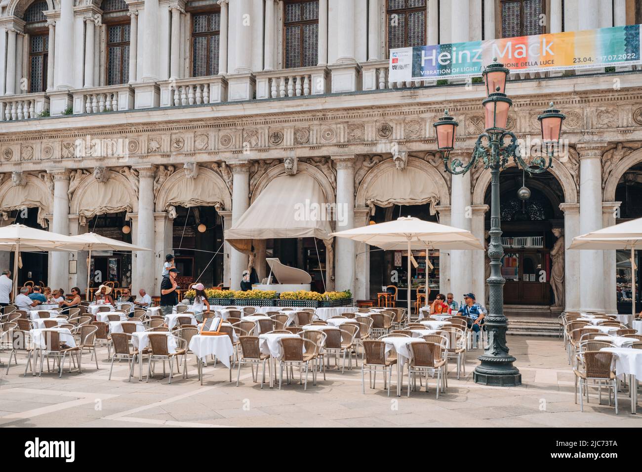 Venice, Italy - May 21, 2022: People at the outdoor tables of Caffe Chioggia in Piazetta San Marco, extension of San Marco square in Venice, capital o Stock Photo