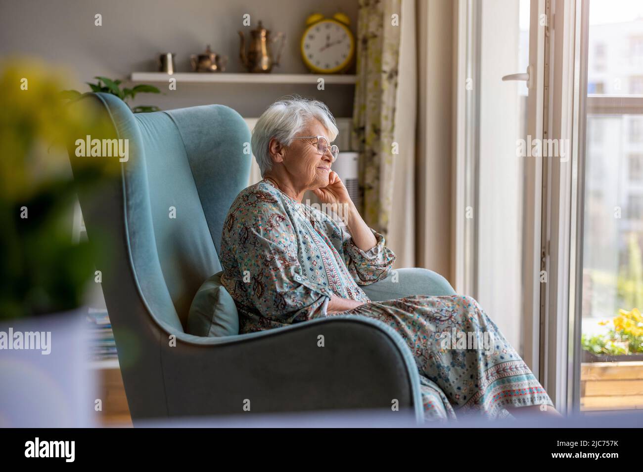 Elderly woman sitting in an armchair in her home Stock Photo - Alamy