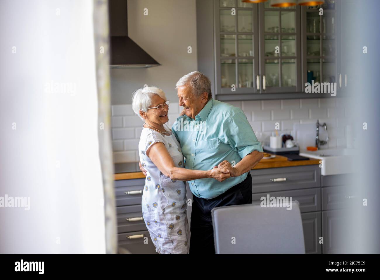 Senior Couple Dancing in their Kitchen Stock Photo