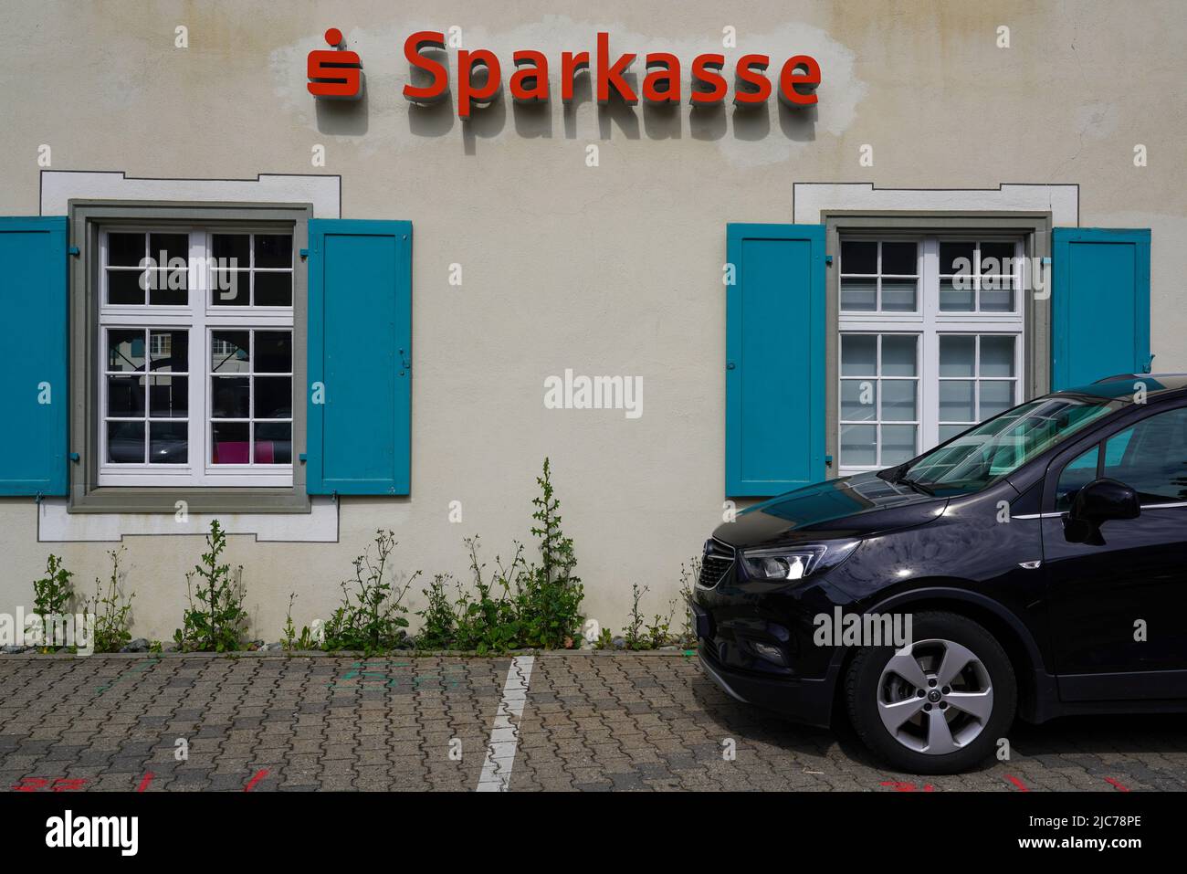 Savings bank sign on a house wall in front of which a car is parked, Aulendorf, Baden-Württemberg, Germany, 6.6.22 Stock Photo