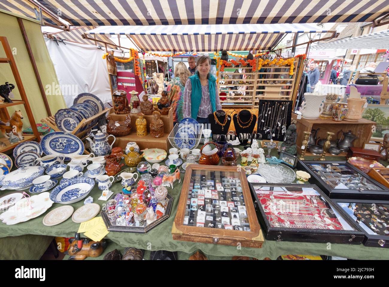 Working woman UK, and her bric and brac market stall; A woman market trader and her stall, Ely Market, Ely Cambridgeshire UK Stock Photo
