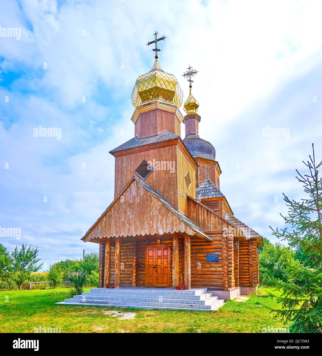 Historical wooden Church of the Intercession in the middle of its fruit garden, Cherevki village, Ukraine Stock Photo