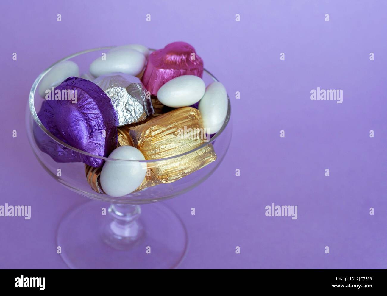 Feast Concept, Traditional Turkish Ramadan sweet sugar candy, and chocolates in glass bowl purple background.elegant. Stock Photo
